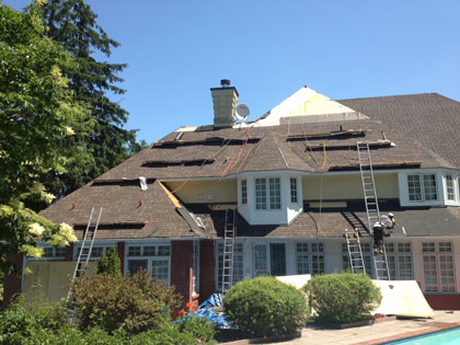 Roof being shingled with new shingles.
