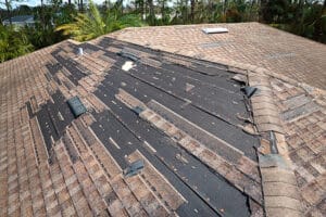 Wind damaged house roof with missing asphalt shingles after hurricane Ian in Ottawa. Roof Repair of home rooftop concept