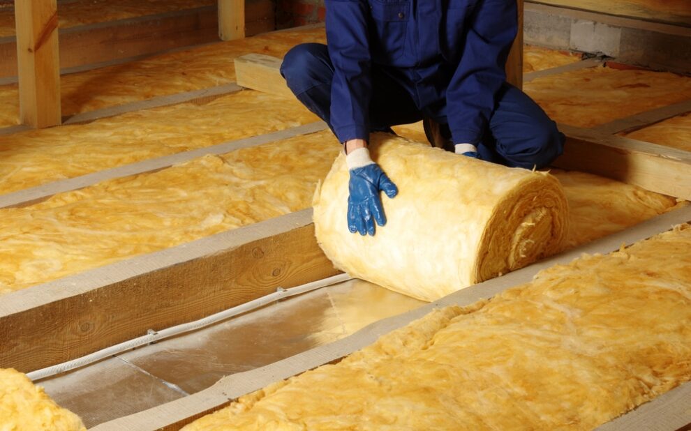 Construction worker thermally proper insulation house attic with fiber glass wool