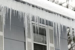 Ice Dams. Ice Build Up In Roof Gutters Icicle On The House Roof In Winter Season.