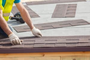 Roof Contractors. Roofer Builder Worker Installing Roof Shingles.