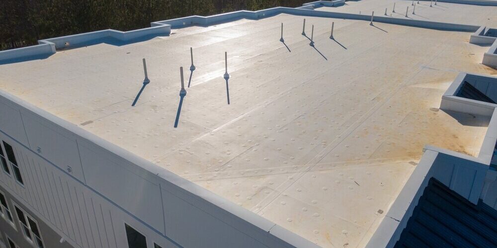 shutterstock_2412750731 (1) Flat Roof Replacement. Aerial view of new flat roof on commercial business.