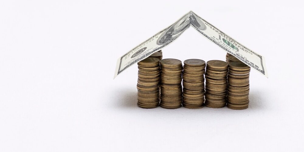 shutterstock_2020788665 (1) What Factors Affect the Cost of Roofing in Ottawa? House made with coins and a roof of dollar bills.