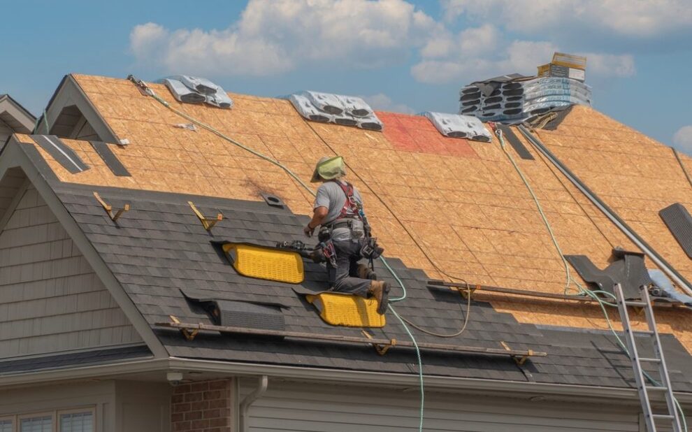 Roof Contractor. Roofers completely replace old asphalt shingle roof during summer in Canada.