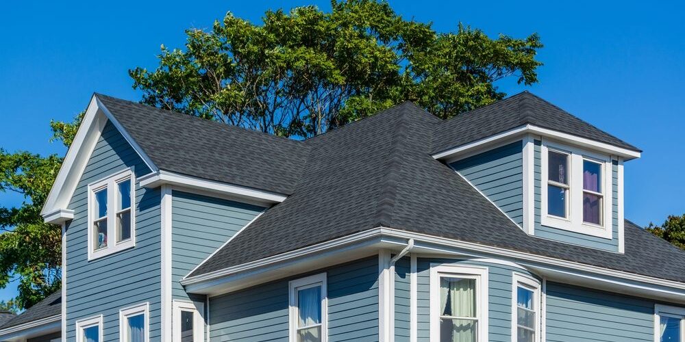 Beautiful,Family,House,With,Blue,Siding,And,White,Trim,In Residential Roofing. Beautiful family house with blue siding and white trim. new roof.