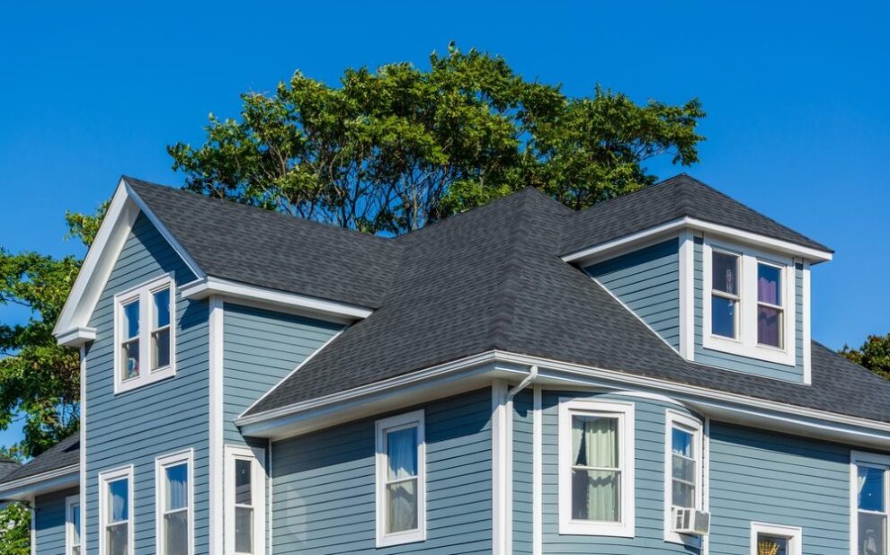 Residential Roofing. Beautiful family house with blue siding and white trim. new roof.