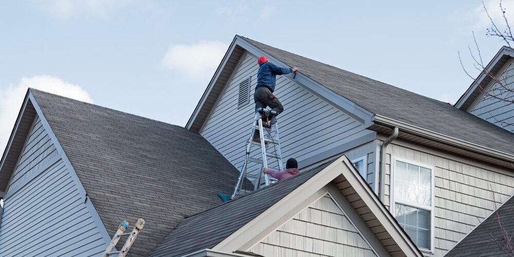 Roofers,Repairing,Damaged,Siding,Trim,Along,Multiple,Roof,Lines,From Godfrey Roofing Ottawa’s Premier Roofing Contractor. Roofers repairing damaged siding trim along multiple roof lines.