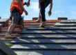 Why Is Godfrey Roofing Ottawa’s Premier Roof Contractor Since 1984? Roofers install slate tiles on a sunny day at a construction site in a suburban area.
