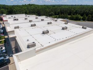 How Does Roof Asset Management Benefit Commercial Clients? Mid-Day Drone Images of Commercial Roofs Featuring TPO and Asphalt Shingles. Strip Mall, Sunny, Outdoors, Architecture.