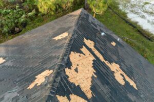 Emergency Roofing Services: What To Do When Your Roof Needs Immediate Repair? missing or damaged shingles. Natural disaster and its consequences. Hurricane destroyed house roof.