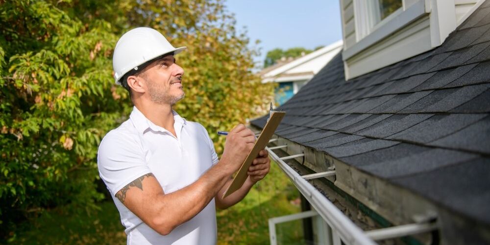 A,Man,With,A,White,Hard,Hat,Holding,A,Clipboard, When to Schedule Professional Roof Inspections for Your Property? A Man with a white hard hat holding a clipboard, inspect house roof.