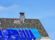 Comprehensive Roof Repairs: How to Identify & Fix Common Roofing Issues. Roof with damaged shingles and blue tarp secured by wooden battens during repair.
