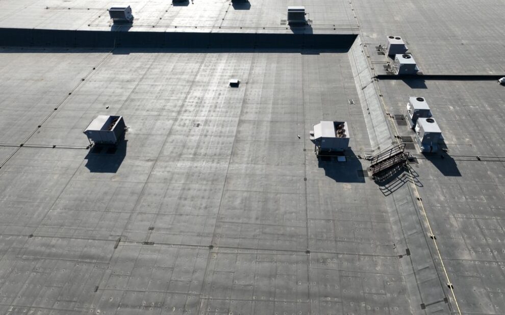 Commercial Roofing in Ottawa: A Strategic Guide for Property Resilience in 2026. A high angle view of a road surface, asphalt flooring and roof from above on a bright sunny day. Transportation is all around.