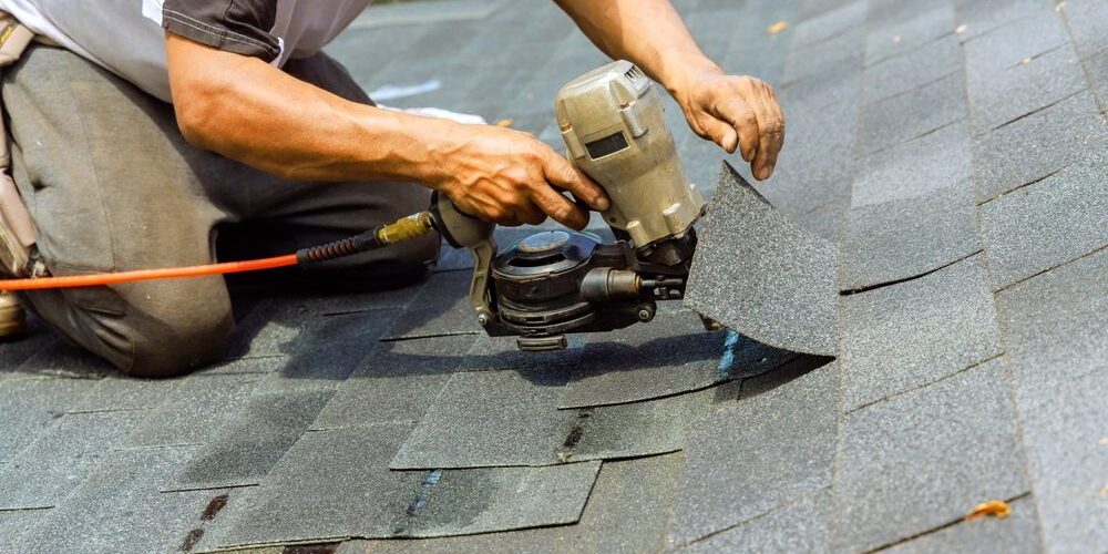 During,Installation,Of,New,Bitumen,Shingles,,Construction,Roofer,Used,Pneumatic Roof Repair vs. Roof Replacement in Ottawa: How to Know What You Need. During installation of new bitumen shingles, construction roofer used pneumatic air nail gun.