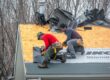Ottawa Residential Roofing Upgrades: Local Trends & Solutions. Calgary, Alberta, Canada. Apr 10, 2025. Two construction workers are installing black underlayment on a plywood roof, preparing for shingles. Tools and bundles of shingles are visible.