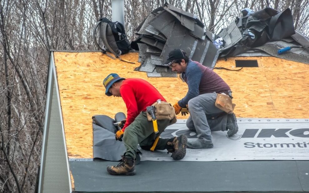 Ottawa Residential Roofing Upgrades: Local Trends & Solutions. Calgary, Alberta, Canada. Apr 10, 2025. Two construction workers are installing black underlayment on a plywood roof, preparing for shingles. Tools and bundles of shingles are visible.