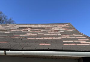 Ottawa Residential Roofing Upgrades: Local Trends & Solutions. Old weathered asphalt shingle roof in urgent need of professional repair or replacement. The image shows significant surface wear, missing granules, and deteriorating shingles, presenting a high risk of water leaks and structural damage. Ideal for roofing contractors and home renovation services.