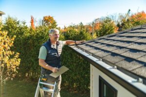 Exploring Career Opportunities: For Roofing Jobs in Ottawa. A man standing on steps inspecting house roof.