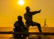 Exploring Career Opportunities: For Roofing Jobs in Ottawa. Two technicians sitting on rooftop at sunset discussing inspection results.